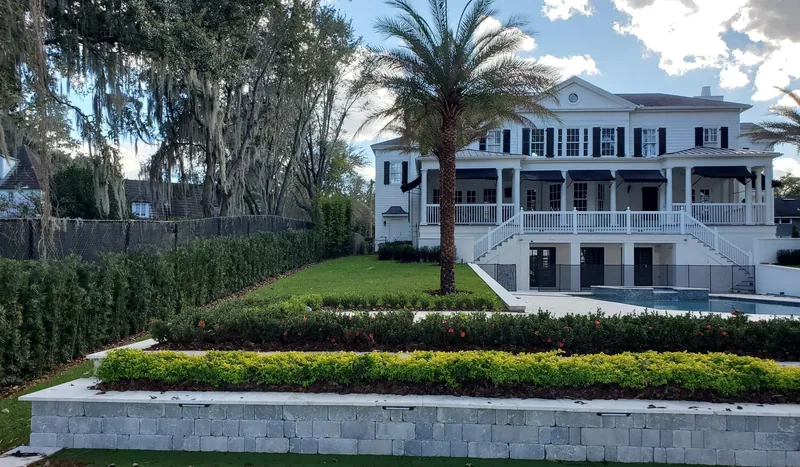A large Central Florida home behind a sharply trimmed hedge line