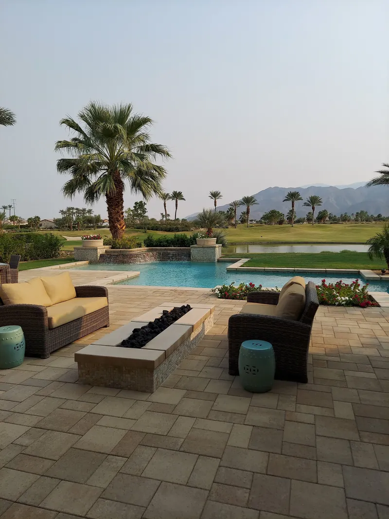 Poolside paver deck under palms