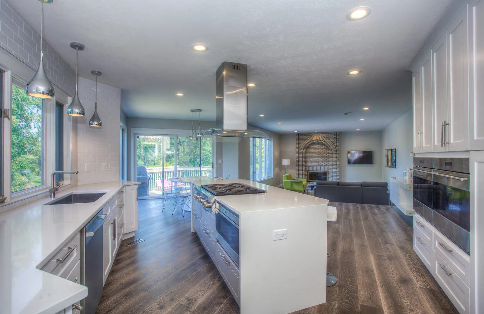 After: an open architectural kitchen with a full-length stone island and integrated joinery