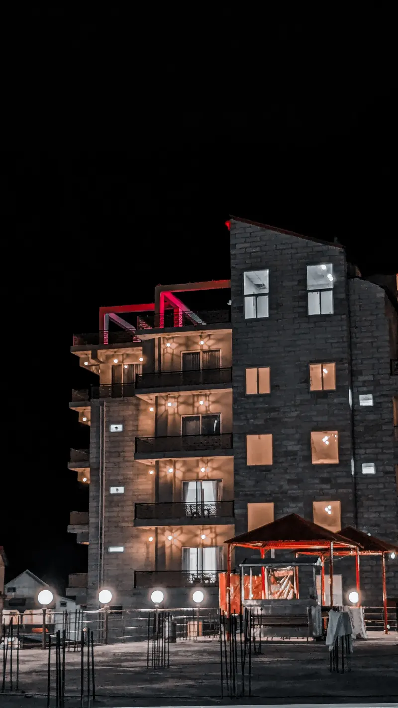 A modern residential building lit at night