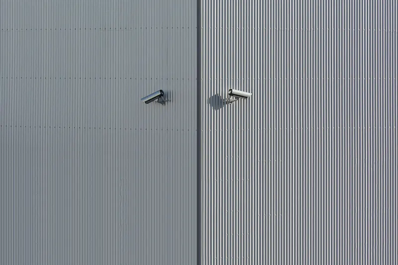 Two small cameras on a corrugated metal elevation
