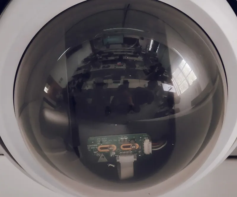 Extreme close-up of a dome camera's lens assembly behind its bubble