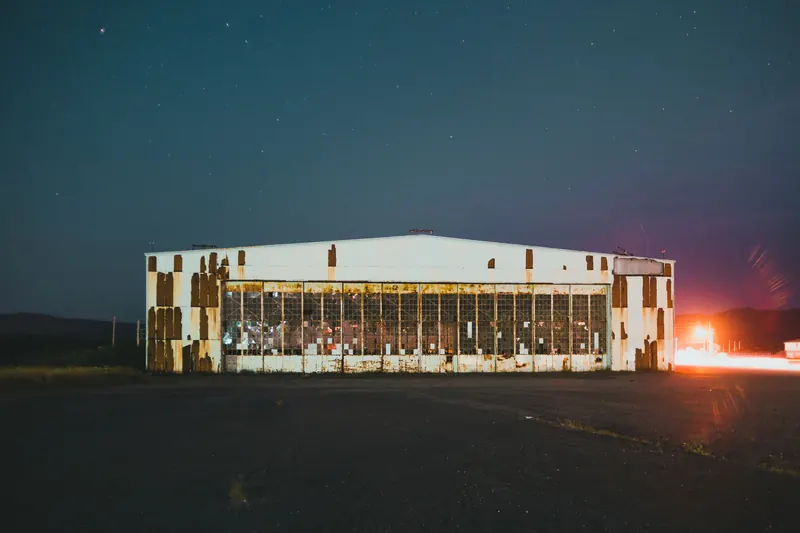 A low commercial building lit against the night sky