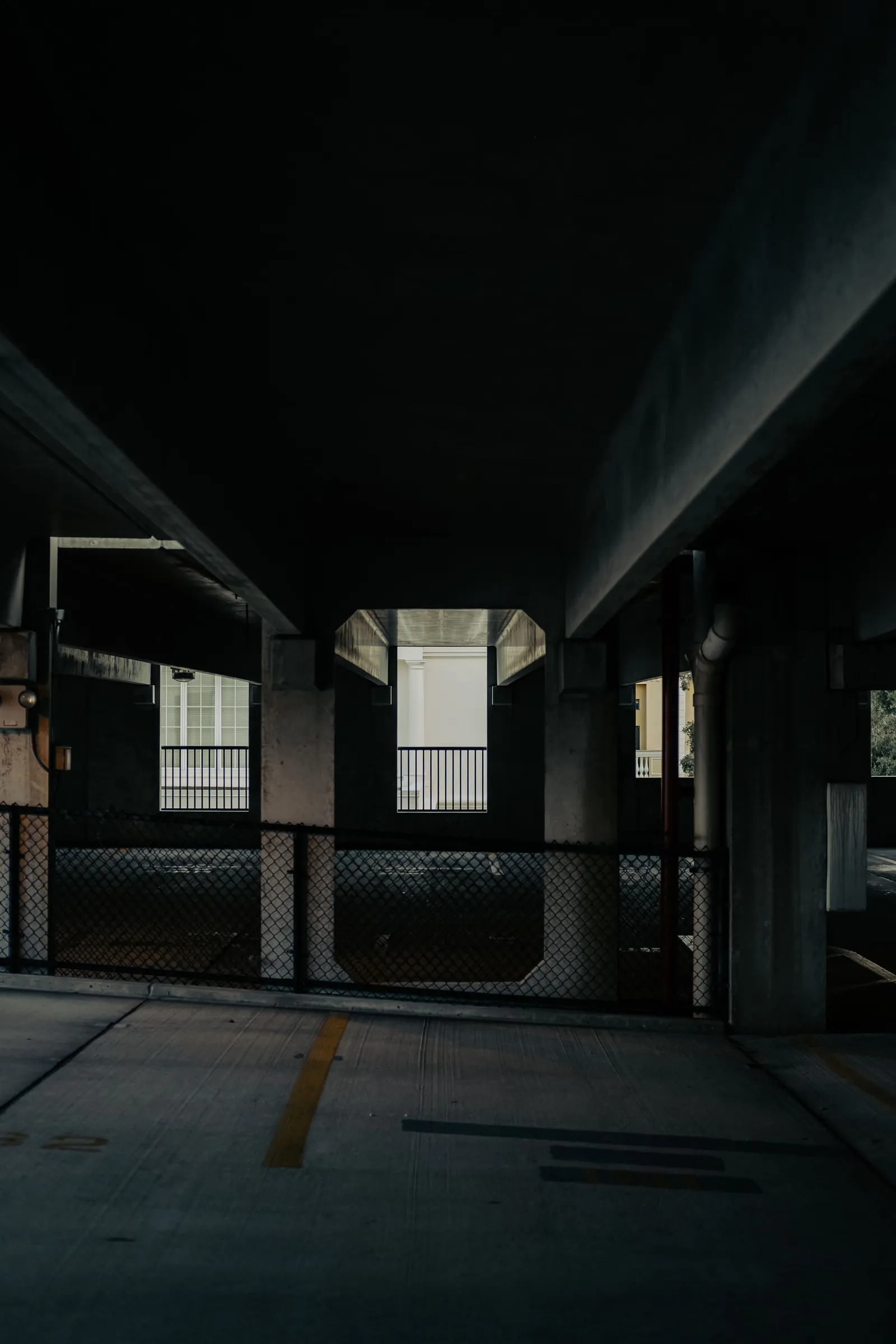 Before: an unlit concrete parking structure with dark corners