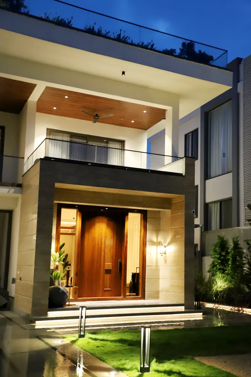 A modern home's lit entrance at night with concealed camera coverage