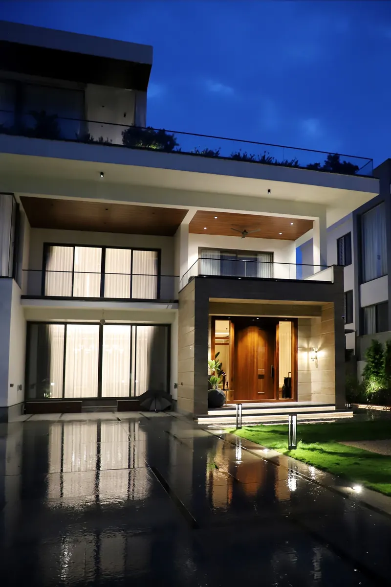 A modern two-storey home lit at night, the kind of property a coverage plan is drawn for