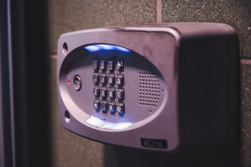 An illuminated entry keypad on an exterior wall at night